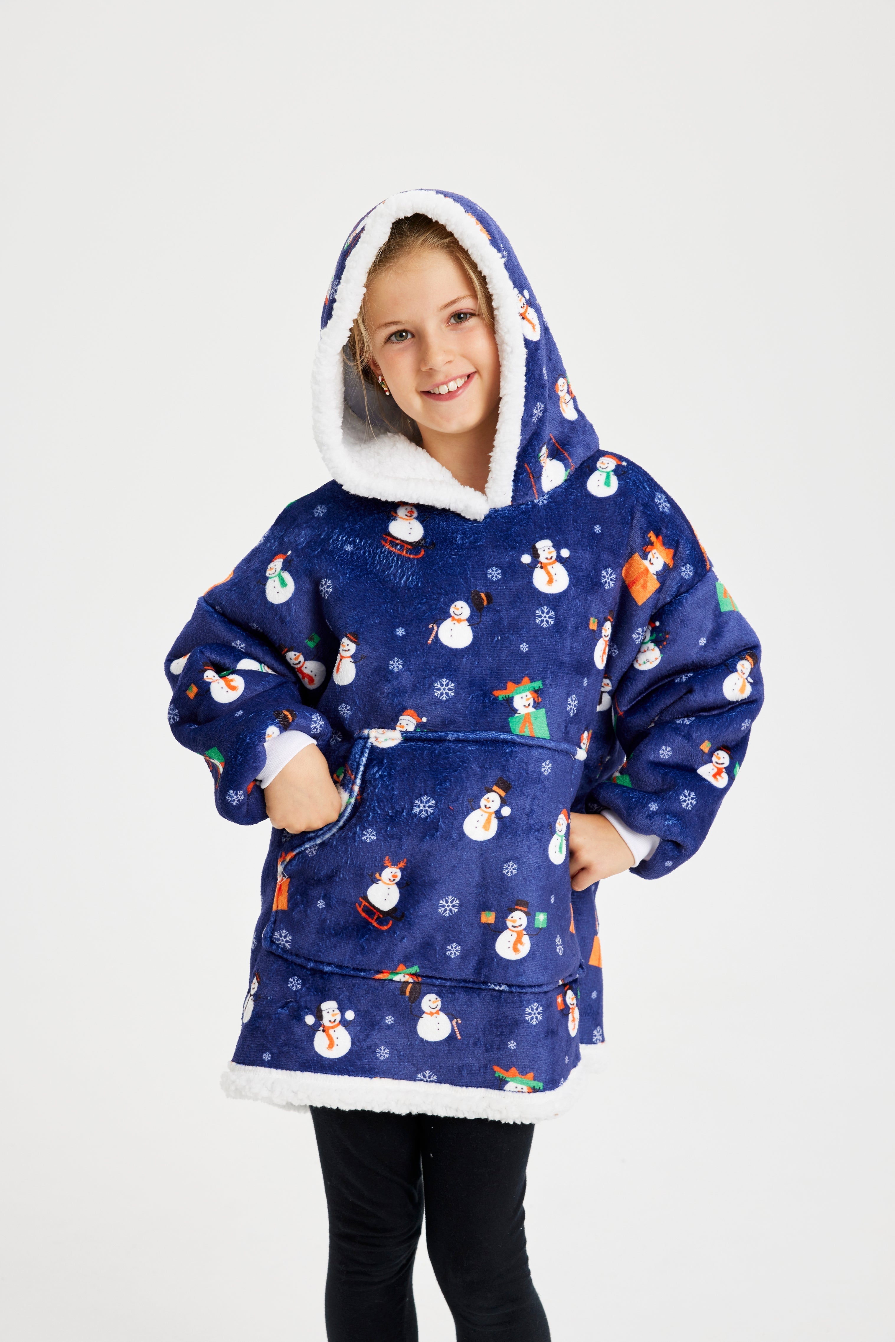 Een lachend kind dat een blauwe kerst hoodie met sneeuwpoppen draagt.